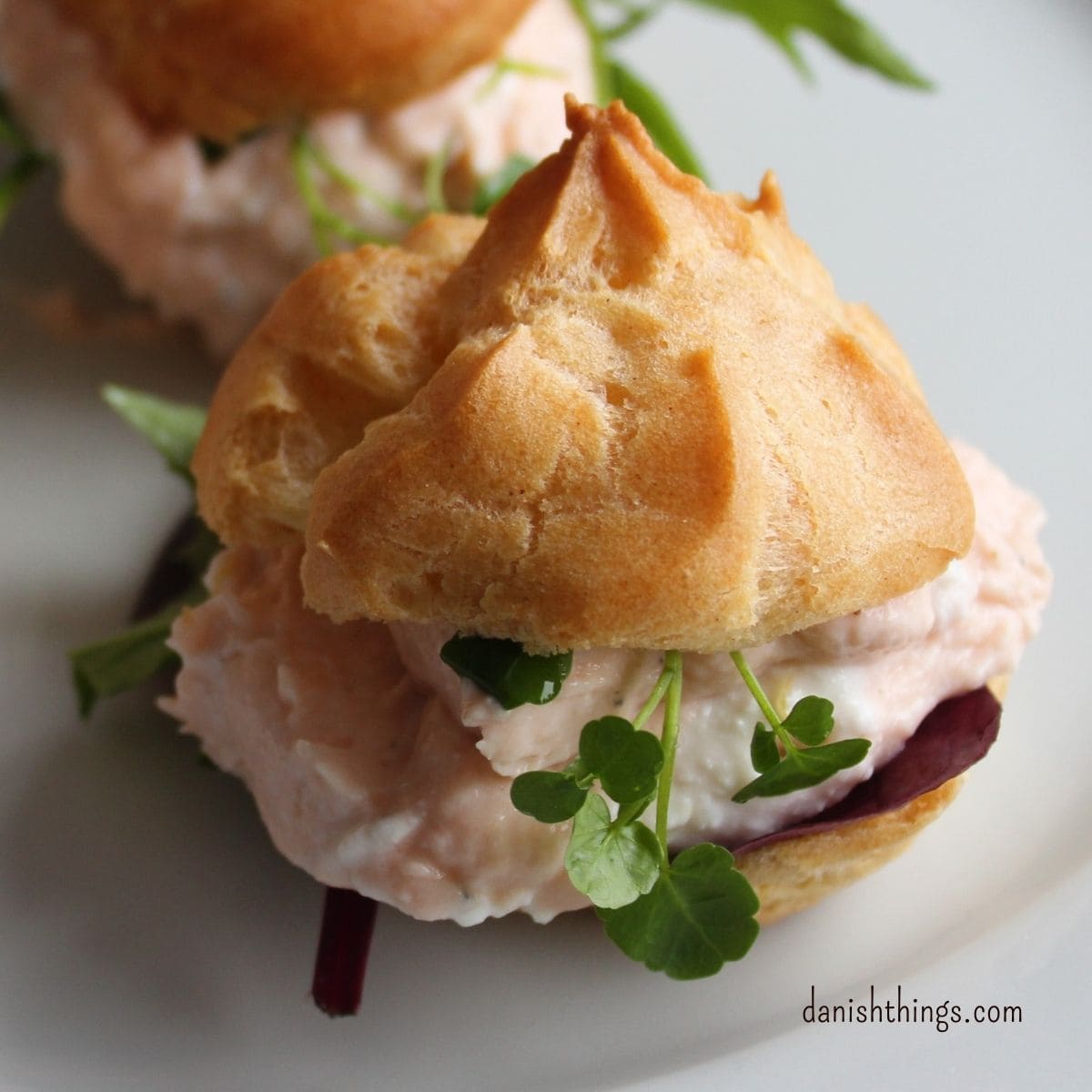 Vandbakkelser med laksemousse af røget laks er lækre som små appetitvækkere, de passer godt til en let frokost eller som en lækker forret. Få tips til bagning af dine vandbakkelser og opskriften på laksemousse af røget laks. Find opskrifter, gratis print og inspiration til årets gang på danishthings.com #DanishThings #laksemousse #røget laks #festlig #vandbakkelse #vandbakkelser #forret #fastelavn #appetizer