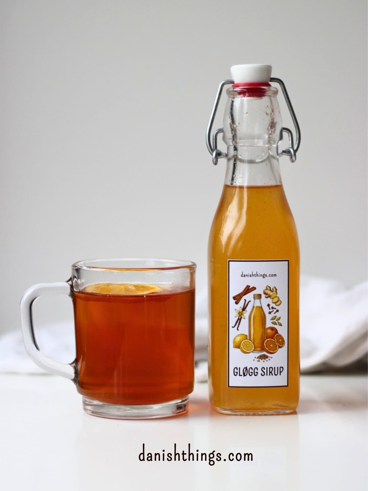 En kop julet tegløgg og en flaske æblegløggsirup.Æblegløggekstrakt og koncentreret gløggsirup (1:1) - den perfekte julegave! 🍎✨
Lær hvordan du laver en hurtig gløggekstrakt og en koncentreret gløggsirup, der kan bruges til alt fra klassisk gløgg og gløggspritz til te, sodavand og det søde køkken – både varm og kold.
Find opskriften, masser af anvendelsesmuligheder og gratis etiketter til print på danishthings.com
© Christel Parby
#DanishThings #gløggsirup #julesirup #gløggekstrakt #æblegløggekstrakt #hjemmelavetgave #æblegløgg #juleopskrifter #julehygge #gløgg #værtindegave #julesmag #opskrift #drinksirup
