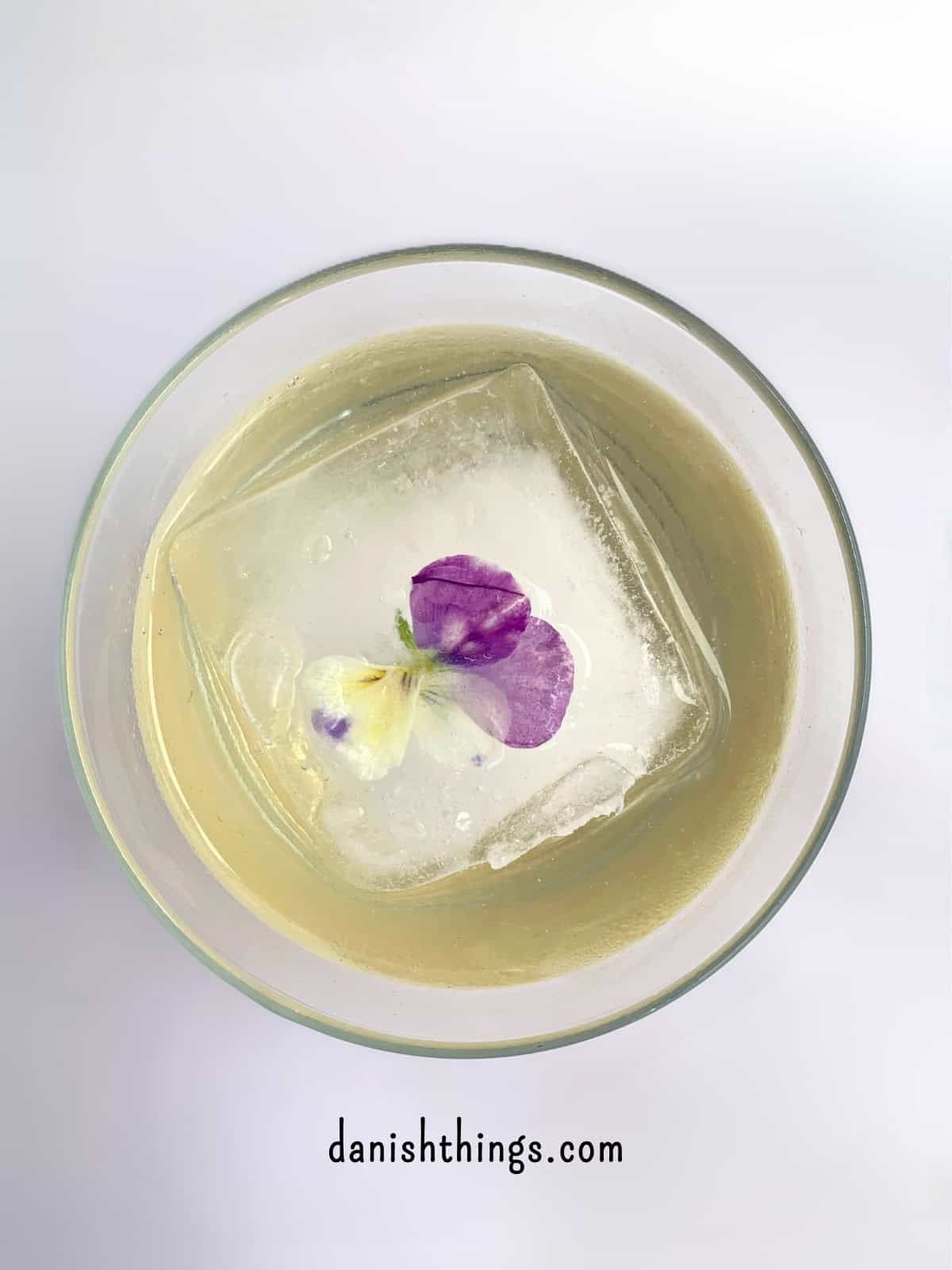 Sommerdrink med dekorativ isterning. Lav en forfriskende hyldeblomstmocktail med kun 4 ingredienser - hvor den ene er isterninger. Tilsæt hjemmelavet hyldeblomstvodka - eller gin, og du har en sommerfrisk cocktail. Find opskriften, variationer og inspiration til sommerens drinks på danishthings.com © Christel Parby #DanishThings #hyldeblomst #hyldeblomstmocktail #hyldeblomstcocktail #mocktail #cocktail #vodkatonic #hyldeblomstvodka #sommerdrink #SpisSommeren