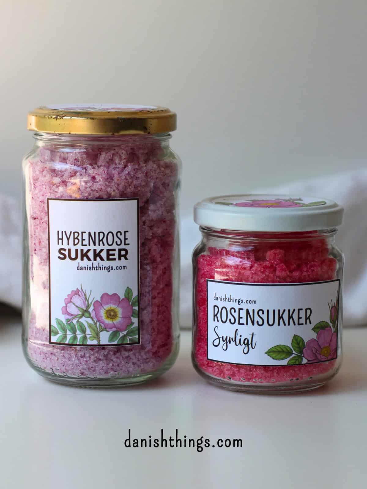 Syrligt rosensukker - smukt pink sukker med hybenroser Vil du lave et rosensukker med en mere holdbar farve? Lav syrligt rosensukker - et smukt pink sukker, der holder farven længe. Perfekt til glasur, marengs og som drys på cookies og kager. Læs mere om det smukke pink blomstersukkers mange anvendelsesmuligheder, find opskriften og de gratis etiketter til rosensukkeret på danishthings.com © Christel Parby #DanishThings #rosensukker #syrligtrosensukker #hybenrose #citronsyre #blomstersukker #surtsukker #GratisEtiketter