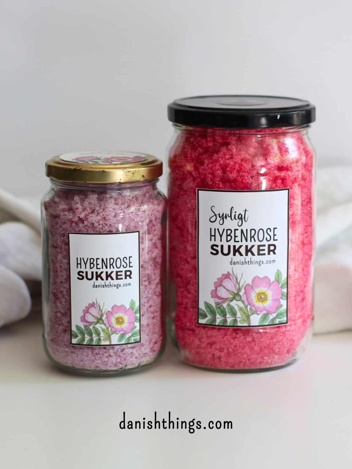 Syrligt rosensukker - smukt pink sukker med hybenroser Vil du lave et rosensukker med en mere holdbar farve? Lav syrligt rosensukker - et smukt pink sukker, der holder farven længe. Perfekt til glasur, marengs og som drys på cookies og kager. Læs mere om det smukke pink blomstersukkers mange anvendelsesmuligheder, find opskriften og de gratis etiketter til rosensukkeret på danishthings.com © Christel Parby #DanishThings #rosensukker #syrligtrosensukker #hybenrose #citronsyre #blomstersukker #surtsukker #GratisEtiketter