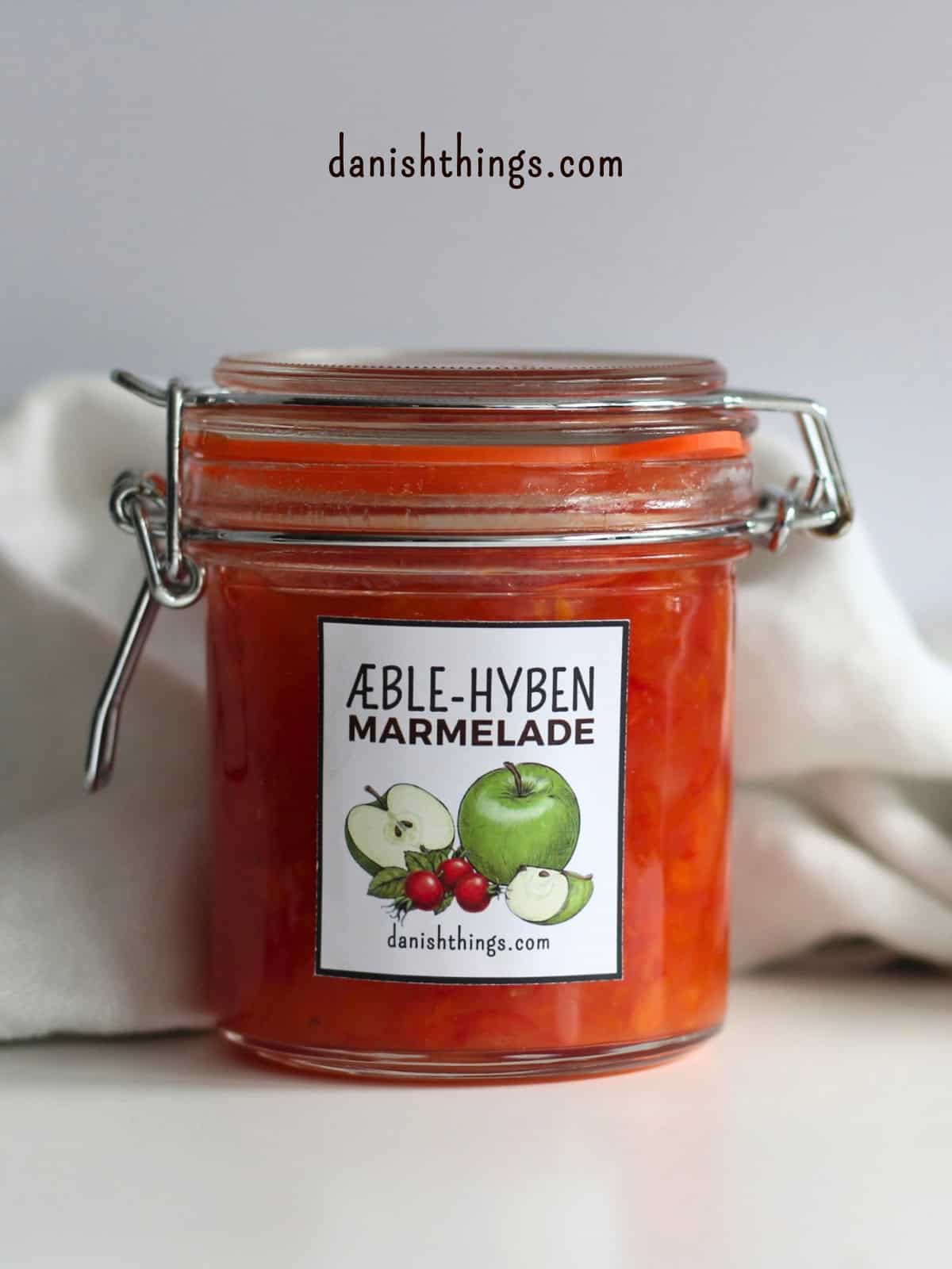 Æblemarmelade med hyben - få en 2-i-1 opskrift, tips og gratis etiketter Klassisk glas med hjemmelavet æble-hybenmarmelade på hvid baggrund. Her får du den fulde opskrift på æblemarmelade med hyben i to versioner – både den klassiske og en mindre sød udgave til køleskabet. Se hele opskriften på danishthings.com © Christel Parby #DanishThings #opskrift #marmelade #efterårskokseri #hjemmelavetmarmelade