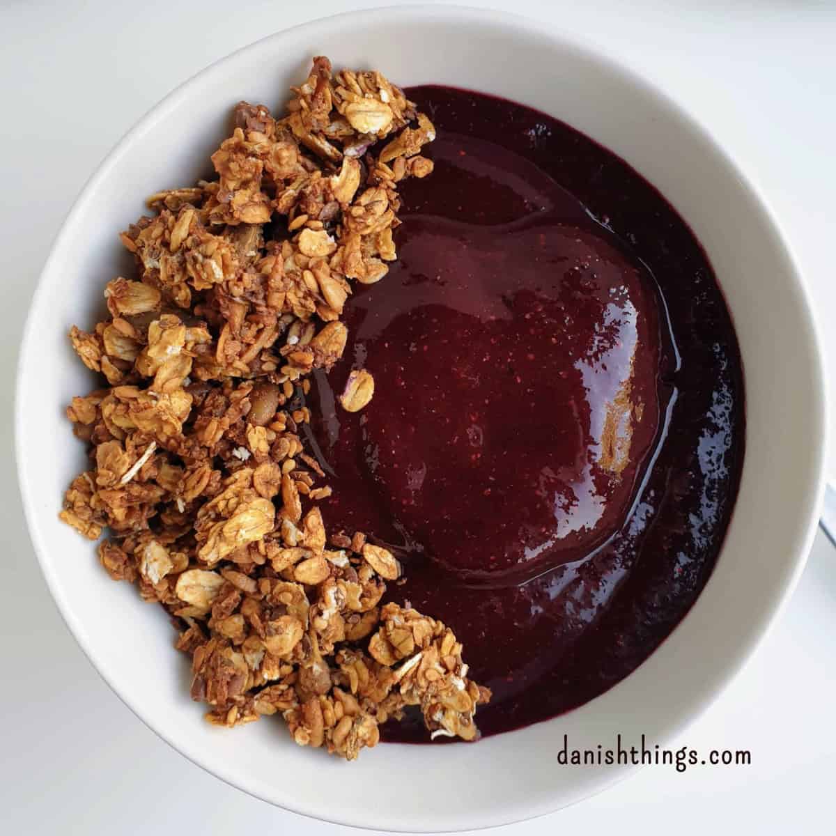 Sprød hverdagsgranola sødet med banan - granola uden tilsat sukker Granola sødet med banan som sprød topping på en blåbærsmoothiebowl. Brug hverdagsgranolaen på smoothie bowls, yoghurt, hytteost eller grød. Få opskriften på granola uden tilsat sukker på danishthings.com © Christel Parby #DanishThings #granola #banan #smoothiebowl #blåbær #morgenmad